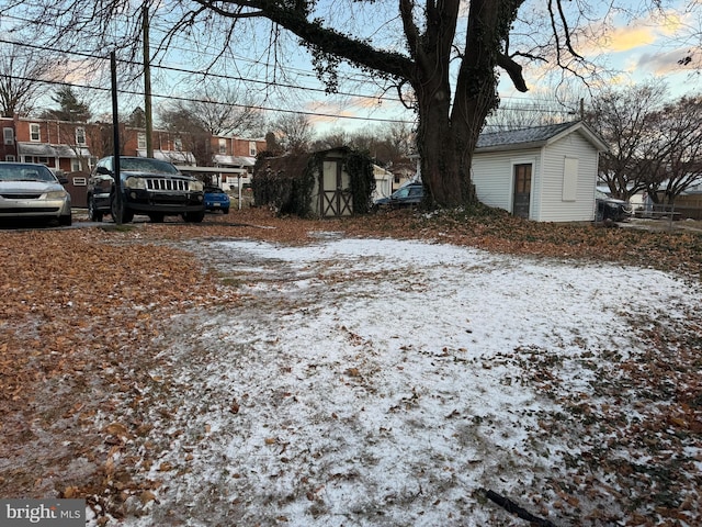 yard covered in snow with a storage shed