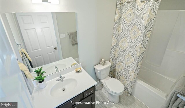 full bathroom with shower / tub combo with curtain, vanity, and toilet