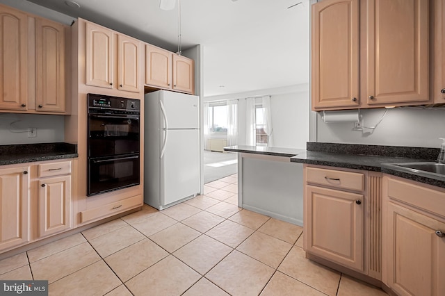 kitchen with light tile patterned floors, white refrigerator, light brown cabinetry, sink, and black double oven