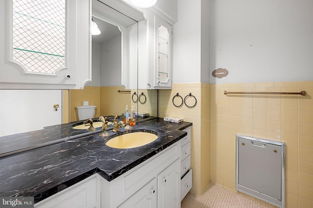 bathroom with a healthy amount of sunlight, tile patterned flooring, vanity, and toilet