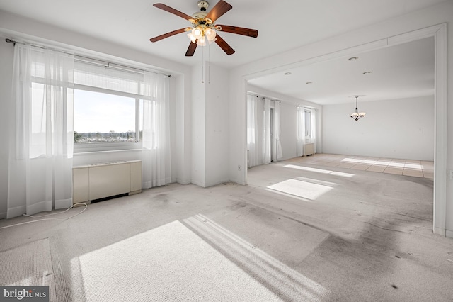 carpeted spare room featuring ceiling fan and plenty of natural light