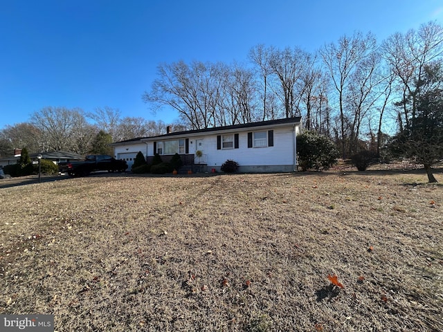 ranch-style home with a garage and a front lawn