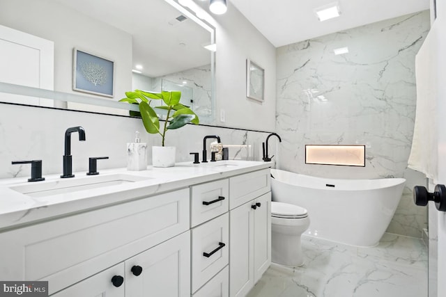 bathroom featuring vanity, a bath, and toilet