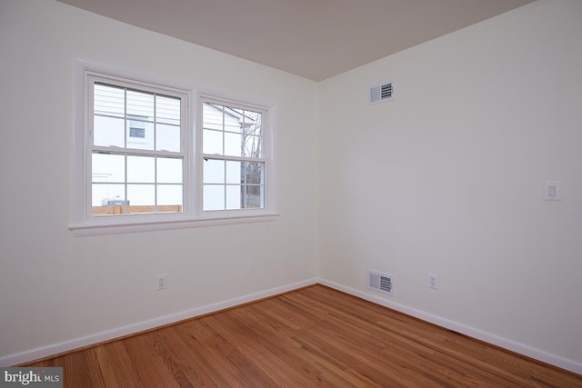 unfurnished room with hardwood / wood-style flooring