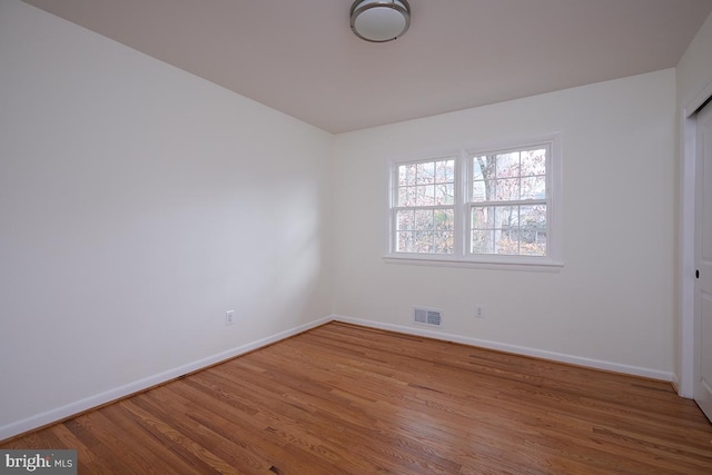 spare room with wood-type flooring