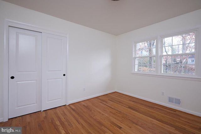 unfurnished bedroom with a closet and hardwood / wood-style floors