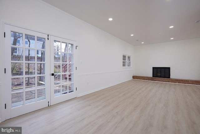 unfurnished living room with light wood-type flooring and a fireplace