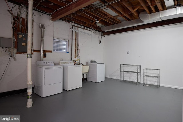 basement featuring electric panel and washing machine and clothes dryer