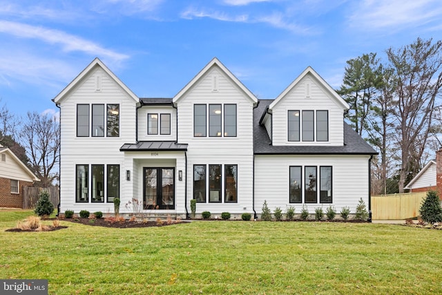 modern farmhouse with roof with shingles, fence, metal roof, and a front yard