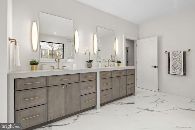 full bath featuring double vanity, marble finish floor, and a sink