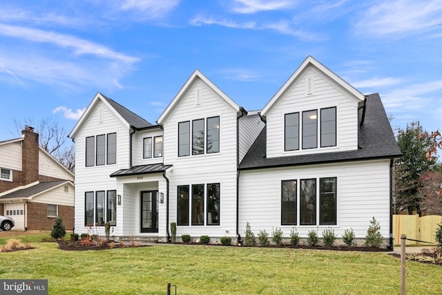 modern inspired farmhouse featuring metal roof, a front lawn, and a shingled roof