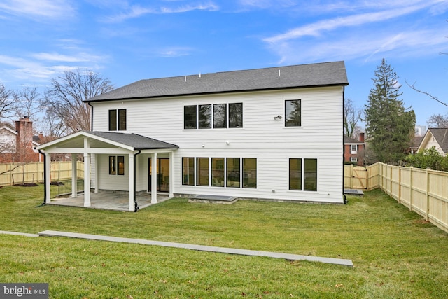 rear view of property with a lawn, a patio area, and a fenced backyard