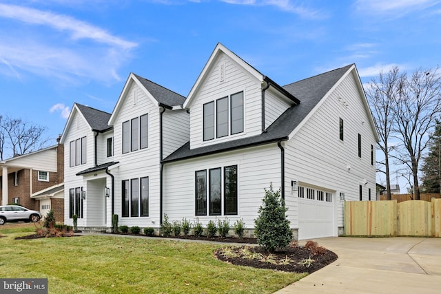 view of front of home with a front yard, concrete driveway, fence, and an attached garage