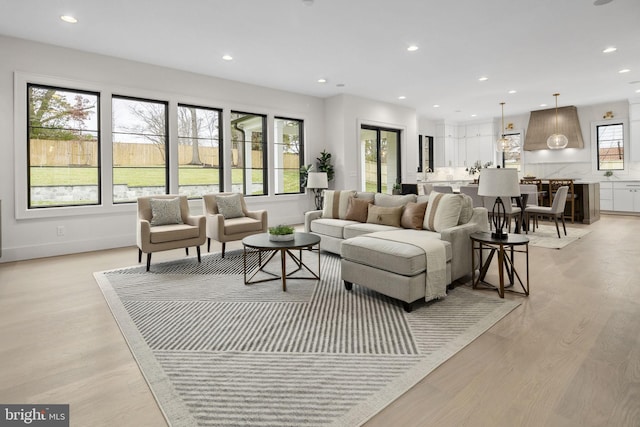 living room with baseboards, light wood-type flooring, and recessed lighting