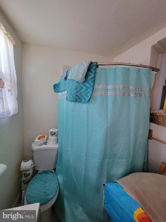 bathroom featuring a textured ceiling and toilet