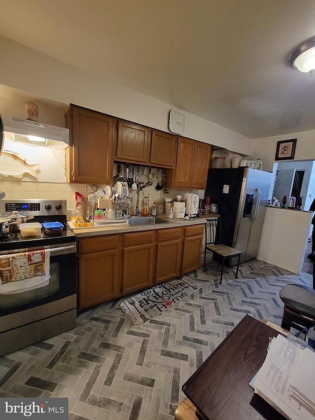 kitchen featuring decorative backsplash, extractor fan, sink, and appliances with stainless steel finishes