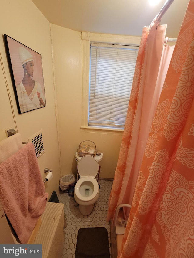 bathroom with tile patterned flooring and toilet