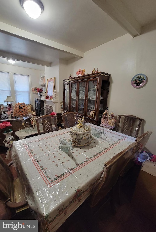 dining area featuring beam ceiling