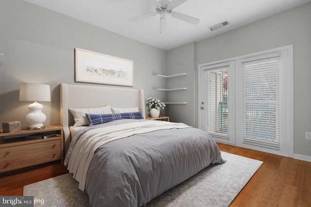 bedroom with ceiling fan, wood-type flooring, and access to outside