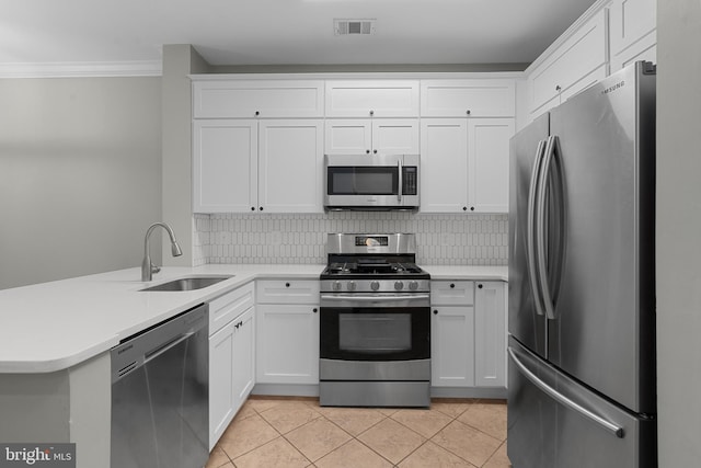 kitchen with white cabinets, sink, ornamental molding, appliances with stainless steel finishes, and kitchen peninsula