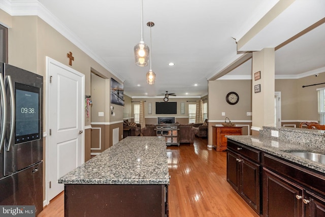 kitchen featuring pendant lighting, ceiling fan, stainless steel fridge, light hardwood / wood-style floors, and a kitchen island