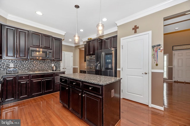 kitchen with dark brown cabinetry, stainless steel appliances, pendant lighting, light hardwood / wood-style floors, and ornamental molding