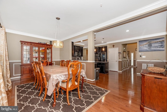 dining room featuring hardwood / wood-style floors and crown molding