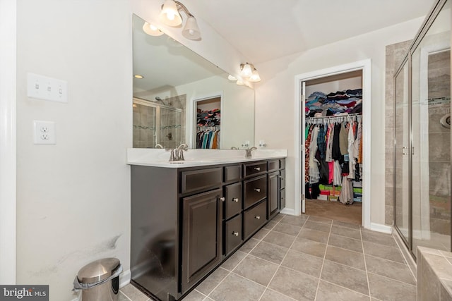 bathroom featuring tile patterned flooring, vanity, and a shower with shower door