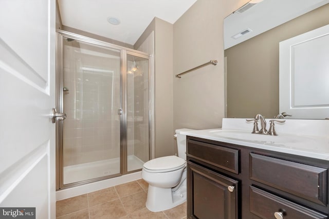 bathroom featuring tile patterned flooring, vanity, toilet, and a shower with door