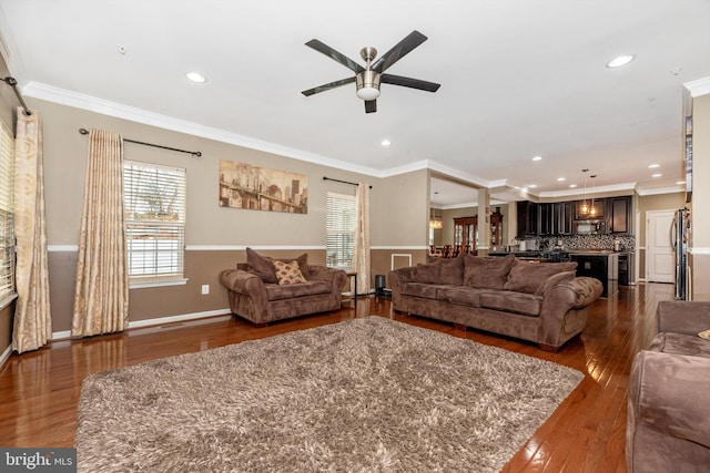 living room with crown molding, dark hardwood / wood-style flooring, and ceiling fan