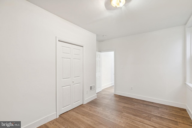 unfurnished bedroom featuring hardwood / wood-style flooring and a closet