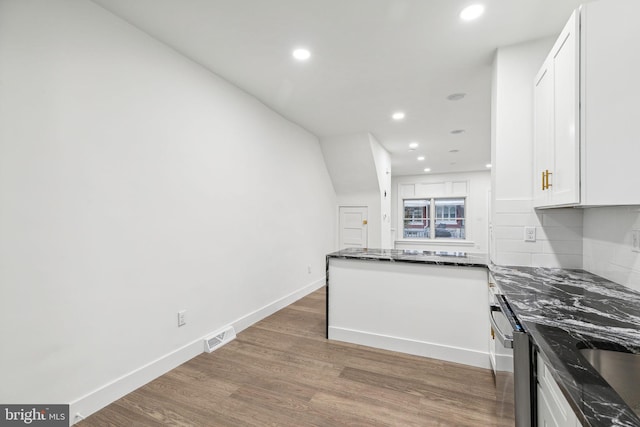 kitchen with dishwasher, dark stone counters, dark hardwood / wood-style floors, tasteful backsplash, and white cabinetry