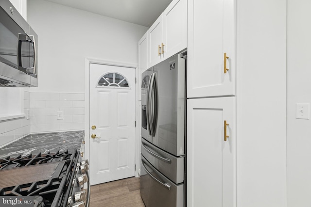 kitchen featuring white cabinets, appliances with stainless steel finishes, and dark hardwood / wood-style floors