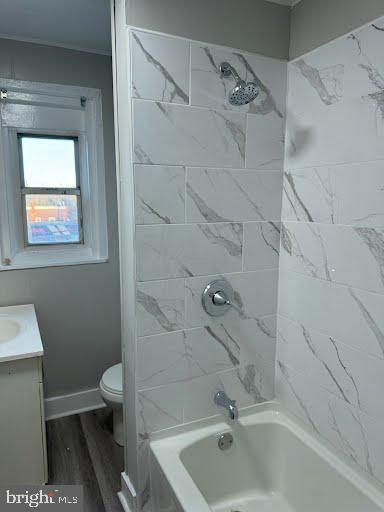 full bathroom with wood-type flooring, vanity, toilet, and tiled shower / bath