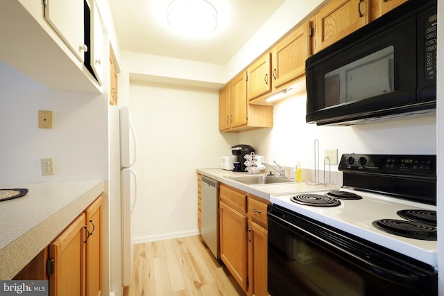 kitchen featuring black appliances, sink, and light hardwood / wood-style flooring