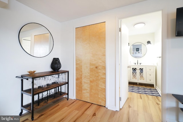 hallway with light hardwood / wood-style flooring and sink