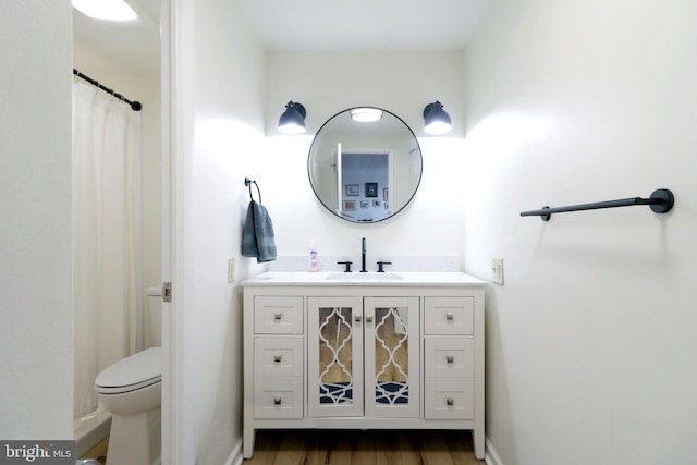 bathroom featuring hardwood / wood-style floors, toilet, vanity, and a shower with curtain