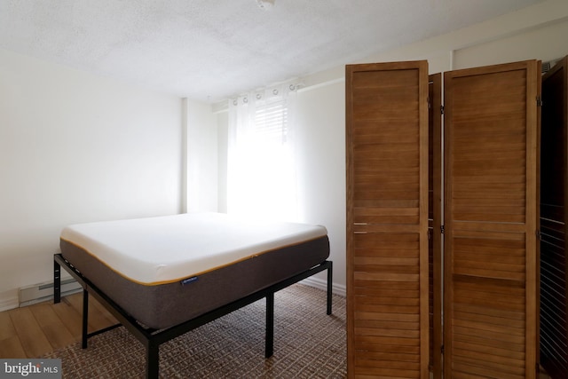 bedroom featuring baseboard heating and a textured ceiling