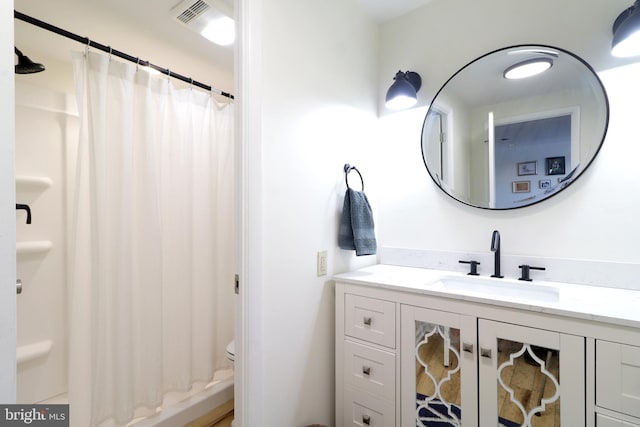 bathroom with toilet, vanity, and a shower with shower curtain