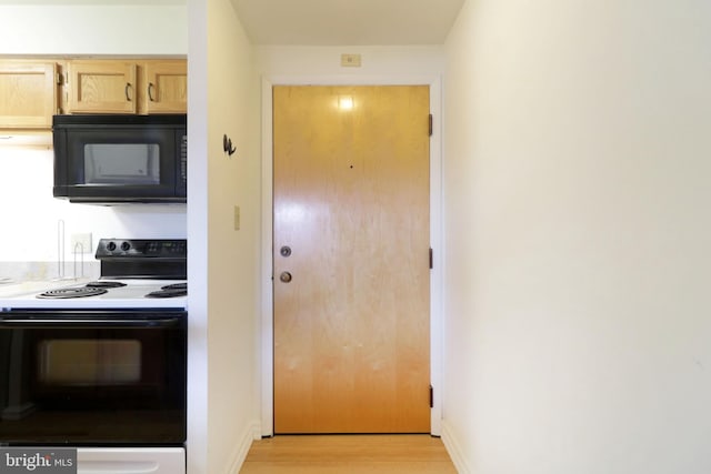 kitchen featuring light wood-type flooring, light brown cabinets, and electric range