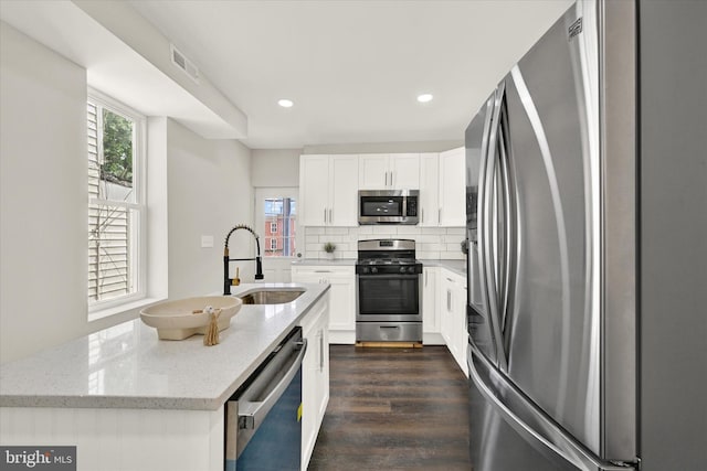 kitchen featuring light stone countertops, sink, dark hardwood / wood-style flooring, white cabinets, and appliances with stainless steel finishes