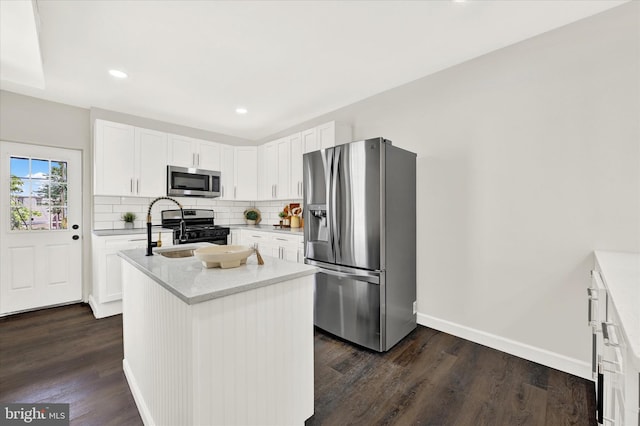 kitchen featuring white cabinets, dark hardwood / wood-style floors, a center island, and appliances with stainless steel finishes