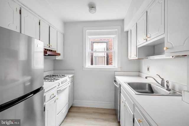 kitchen with sink, white cabinets, light hardwood / wood-style flooring, and appliances with stainless steel finishes