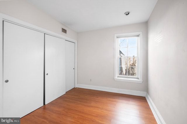 unfurnished bedroom with light hardwood / wood-style flooring and a closet