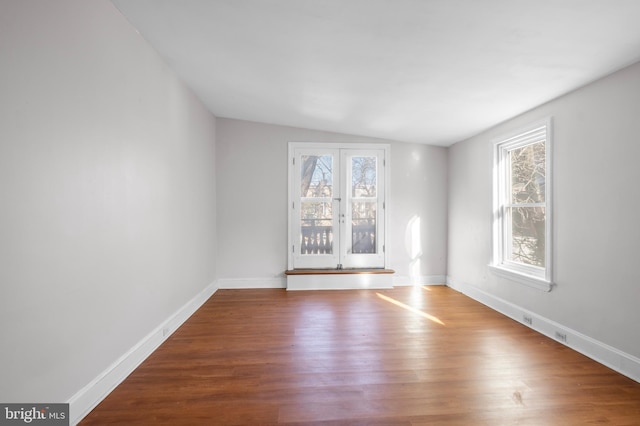 empty room with wood-type flooring and lofted ceiling