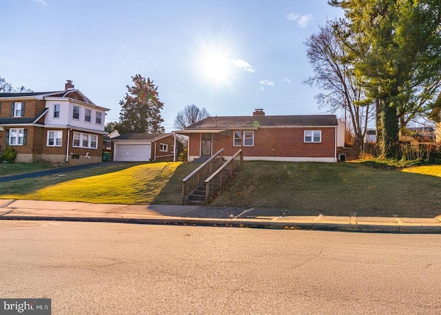 view of front of house with a front yard, an outdoor structure, and a garage