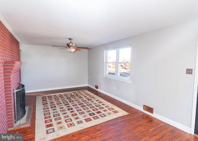 unfurnished living room featuring ceiling fan, wood-type flooring, and a fireplace