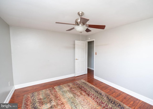 empty room featuring ceiling fan and dark wood-type flooring