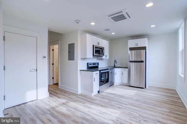 kitchen featuring sink, white cabinets, stainless steel appliances, and light hardwood / wood-style flooring