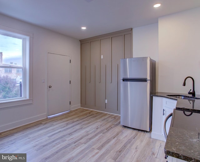 kitchen featuring light hardwood / wood-style flooring, stainless steel refrigerator, a healthy amount of sunlight, and sink